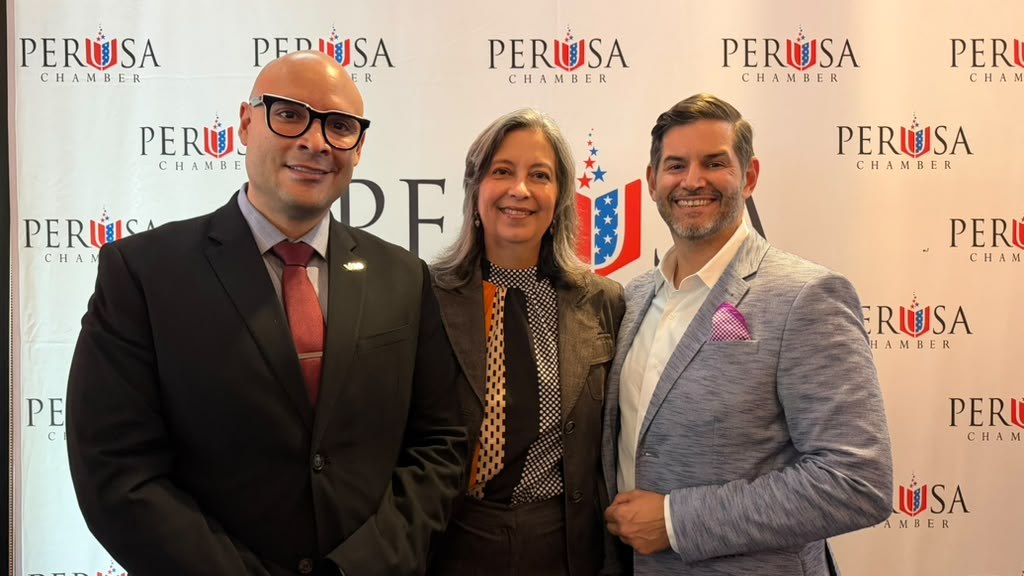 Tres representantes de la red de cámaras binacionales sonríen frente al backdrop de PERUSA Chamber en el evento Perú Gourmet